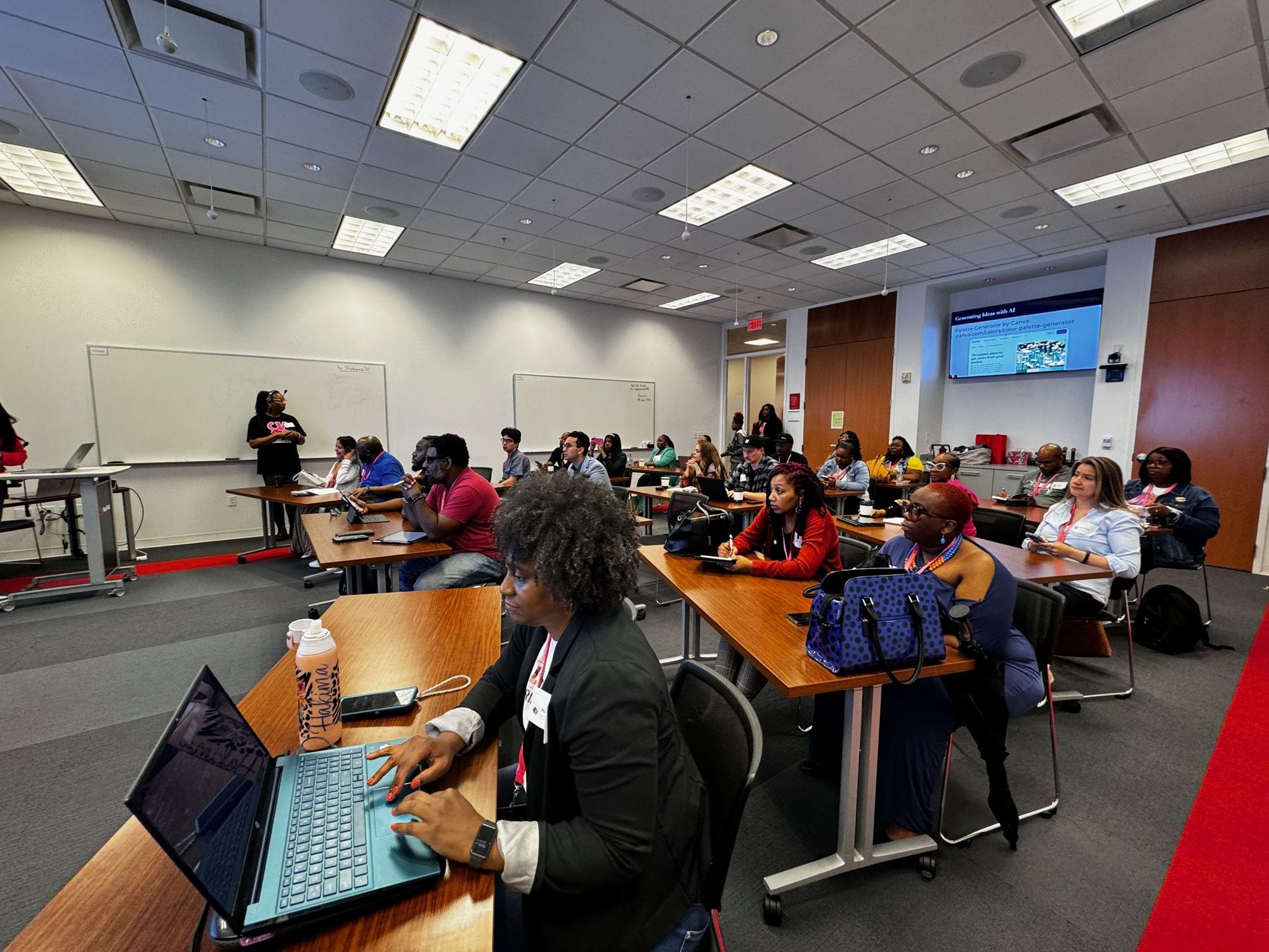A full workshop room of creative professionals working on laptops
